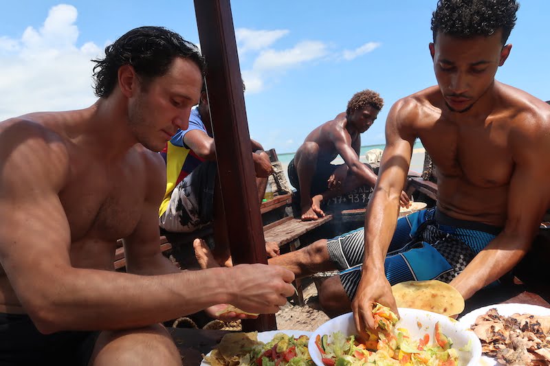 Eating salad and fish with our hands with friends on a boat in Kenya