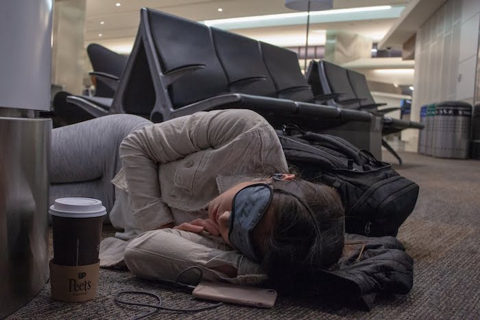 Kim sleeping on the floor in an airport