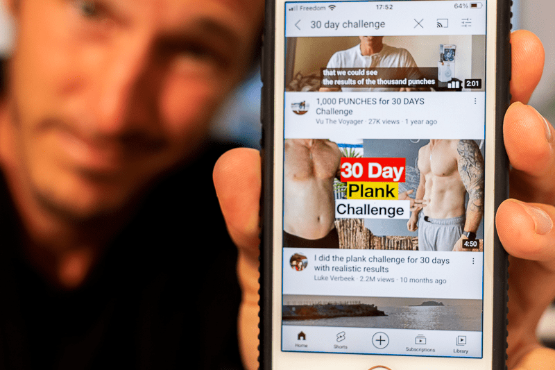 Holding up phone showing the cover image of a remarkable 30-day challenge transformation