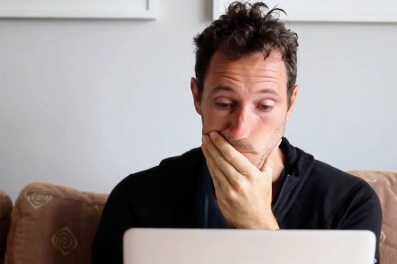 Chris on his computer looking concerned and fed up. 