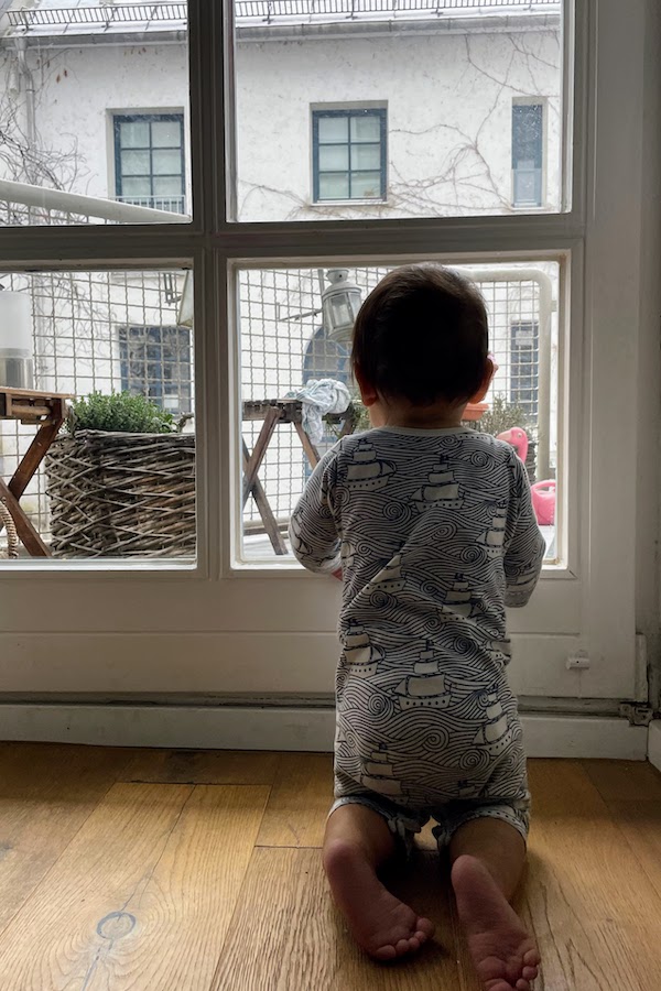 Kid at window looking outside longing for fresh air. 